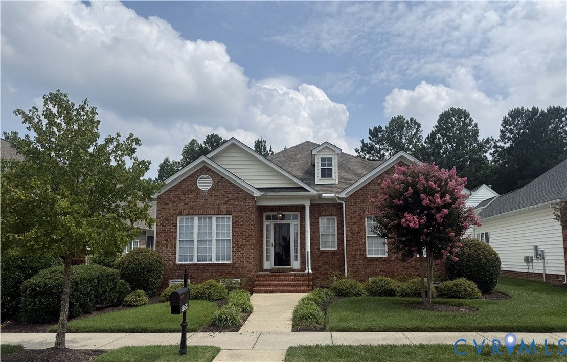 4309 Village Creek Drive, Chester, VA 23831 Brick facade home featuring a prominent front gable, dormer windows, and a manicured front lawn with mature landscaping