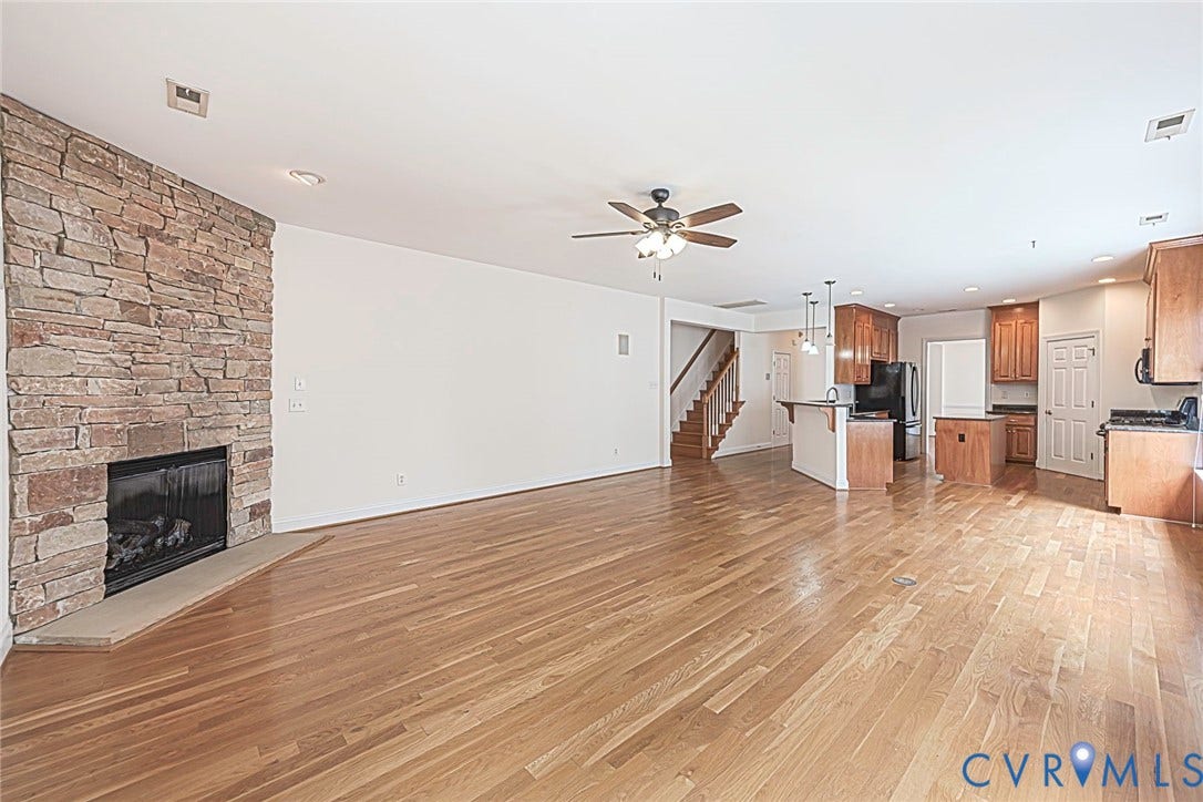 4309 Village Creek Drive, Chester, VA 23831 Open concept interior featuring wood-finish flooring throughout, stone natural gas stone fireplace, open to kitchen.