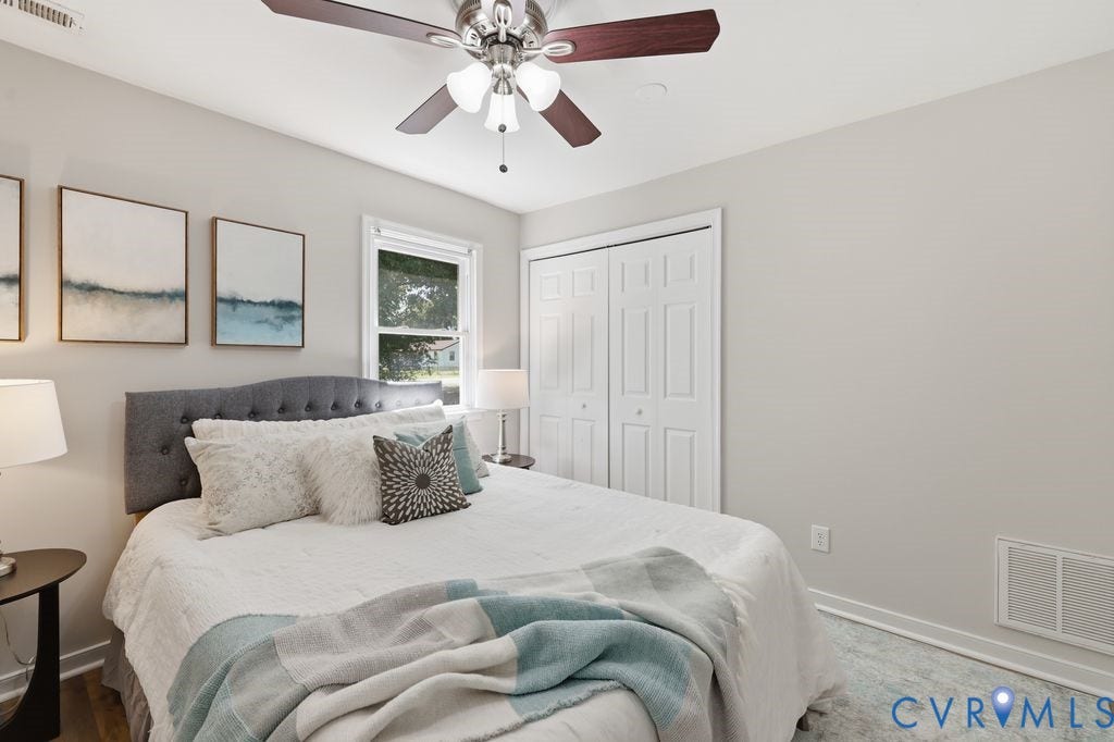 Room featuring light gray walls, a window with white trim, and wood-finish flooring