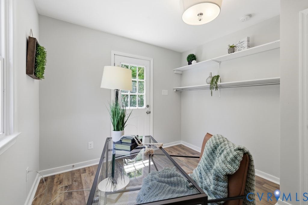 Versatile room featuring wood-finish flooring, light grey wall paint, and a multi-pane glass door providing exterior access
