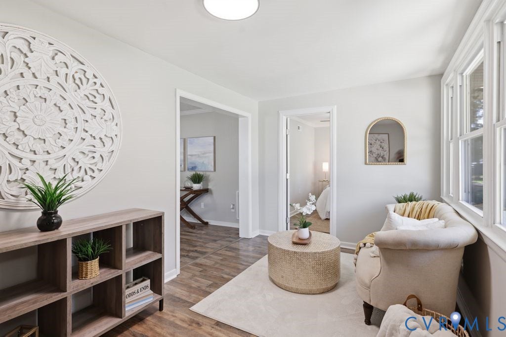 Bright interior space featuring wood-finish flooring, white trim, and multiple large windows