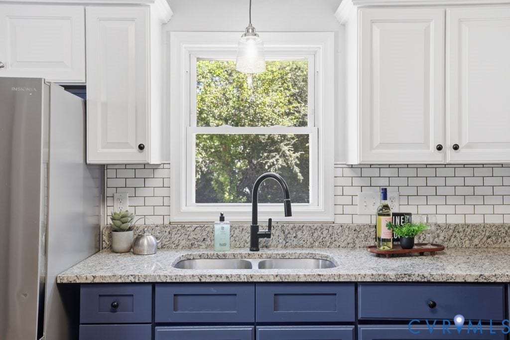 Kitchen featuring white shaker upper cabinetry and blue shaker lower cabinetry with dark hardware