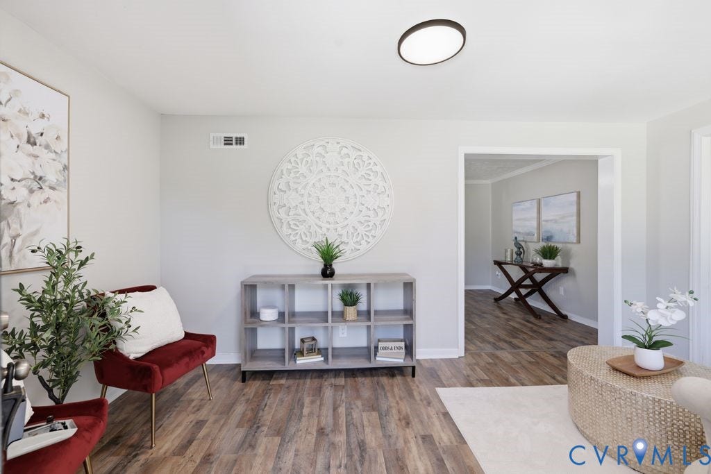 Spacious room featuring wood-finish flooring, light gray wall paint, and a modern flush-mount ceiling light