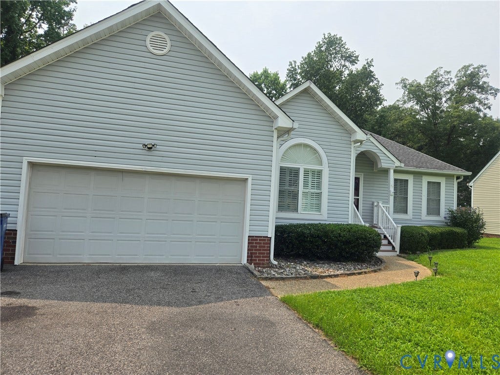 12812 Winfree Street, Chester, VA 23831 Light gray siding exterior with a two-car garage featuring a paneled door