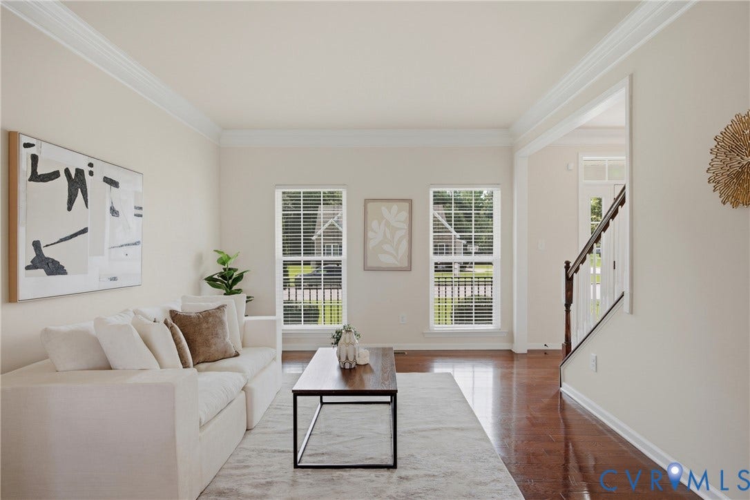 1819 White Mountain Drive, Mount Blanco On The James, Chester, VA 23836 Bright living space featuring warm wood-finish flooring, white crown molding, and two large windows with horizontal blinds