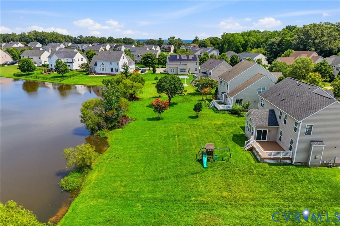 1819 White Mountain Drive, Mount Blanco On The James, Chester, VA 23836 Expansive green lawn with mature trees bordering a serene body of water