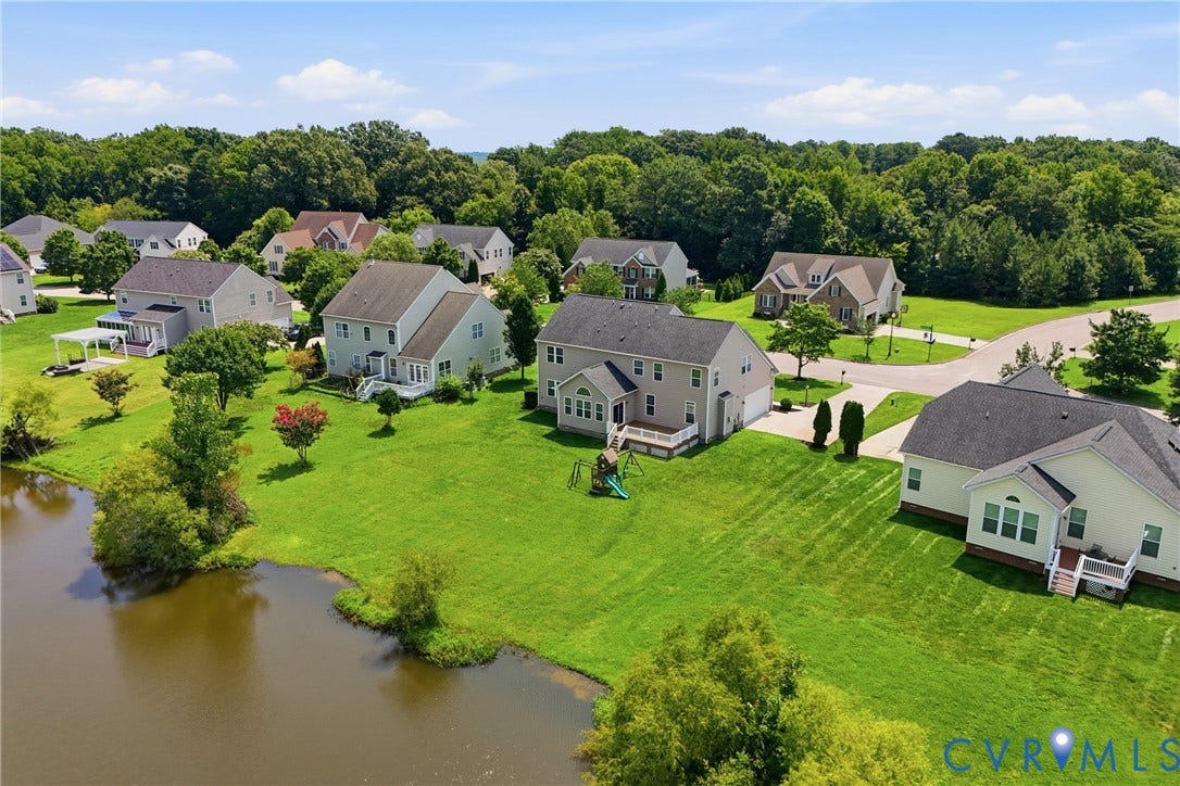 1819 White Mountain Drive, Mount Blanco On The James, Chester, VA 23836 Waterfront property featuring a spacious green lawn, mature trees, and a residential community setting