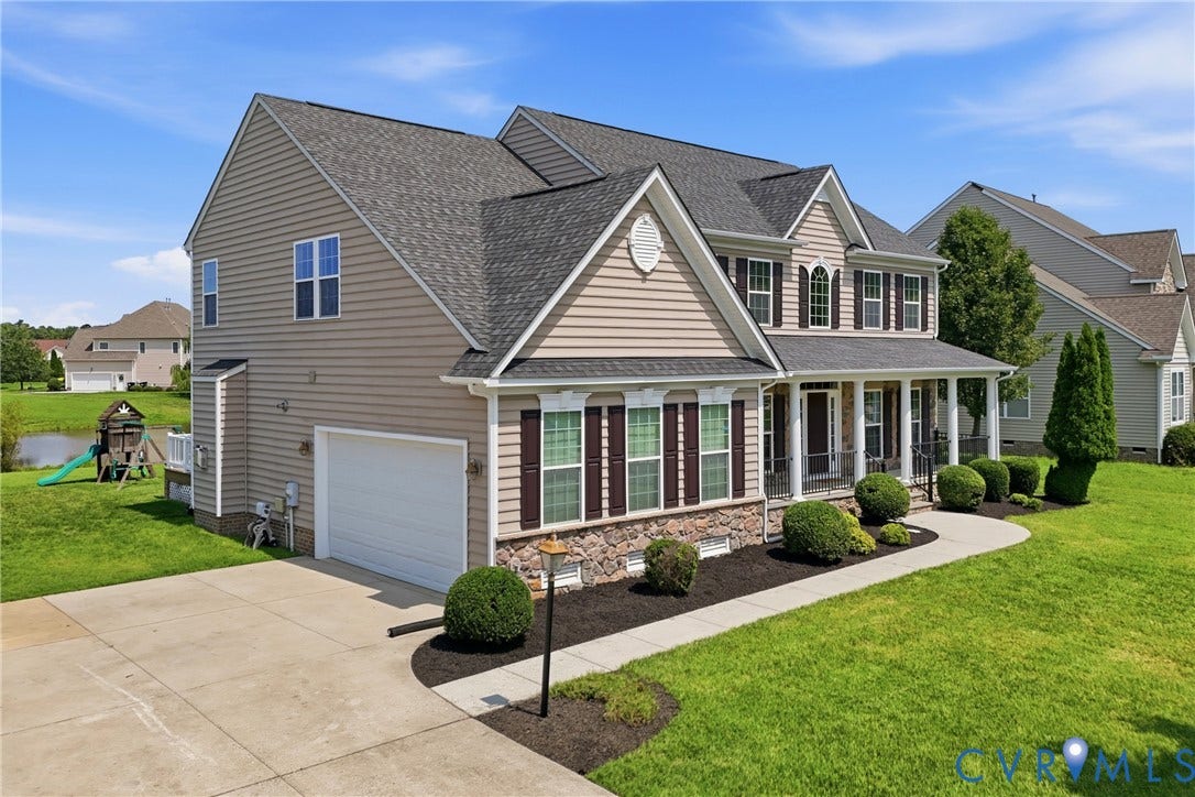1819 White Mountain Drive, Mount Blanco On The James, Chester, VA 23836 Colonial-style residence featuring a two-car garage, covered porch with white columns, stone faade accents, and dark window shutters