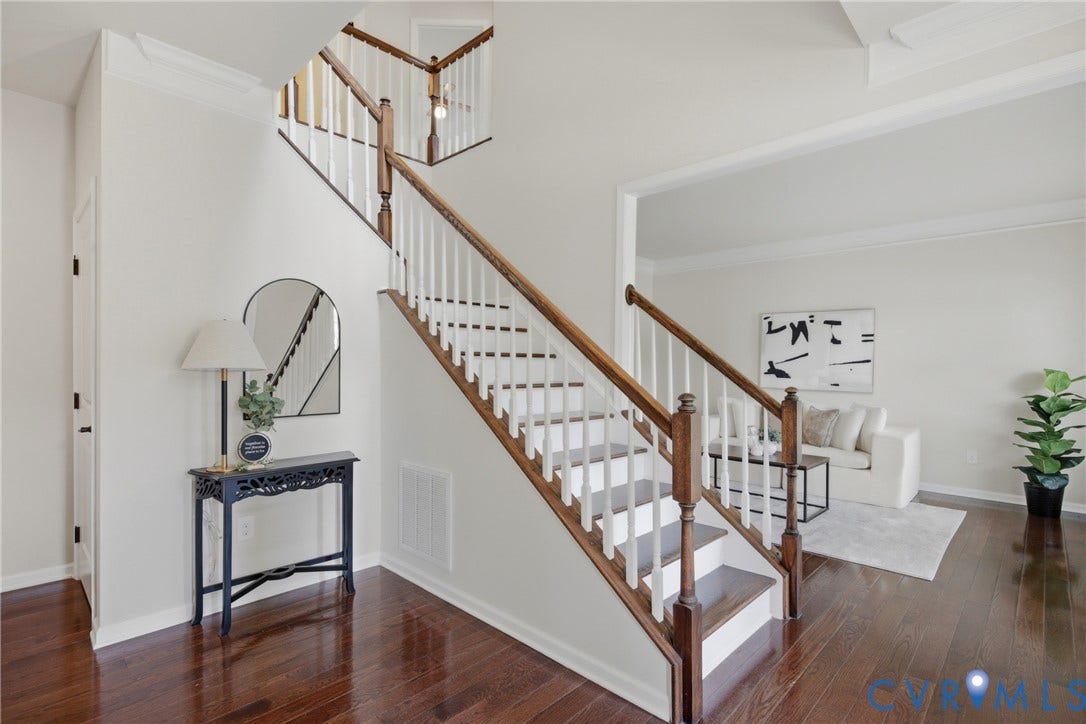 1819 White Mountain Drive, Mount Blanco On The James, Chester, VA 23836 Grand entryway featuring rich wood-finish flooring, a two-story staircase with dark wood handrails and white balusters, and crown molding