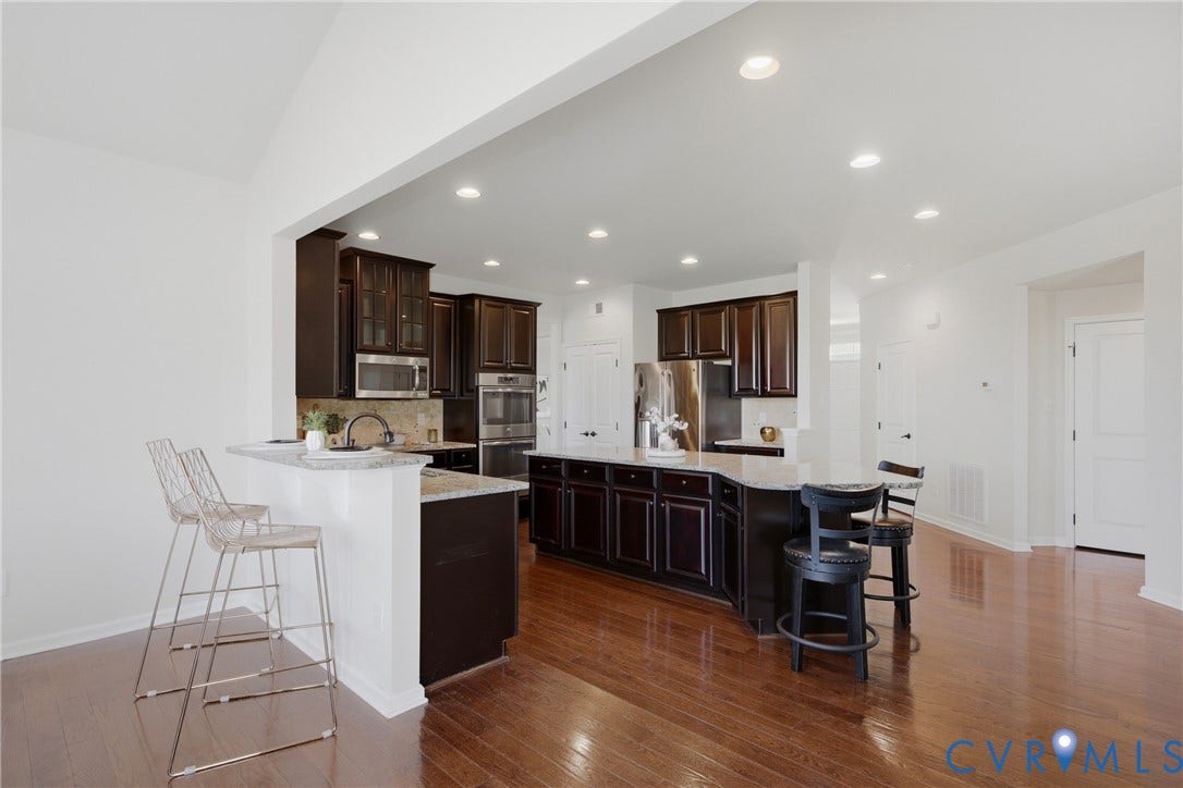 1819 White Mountain Drive, Mount Blanco On The James, Chester, VA 23836 Kitchen featuring dark wood cabinetry, stainless steel appliances, light-toned countertops, and wood-finish flooring