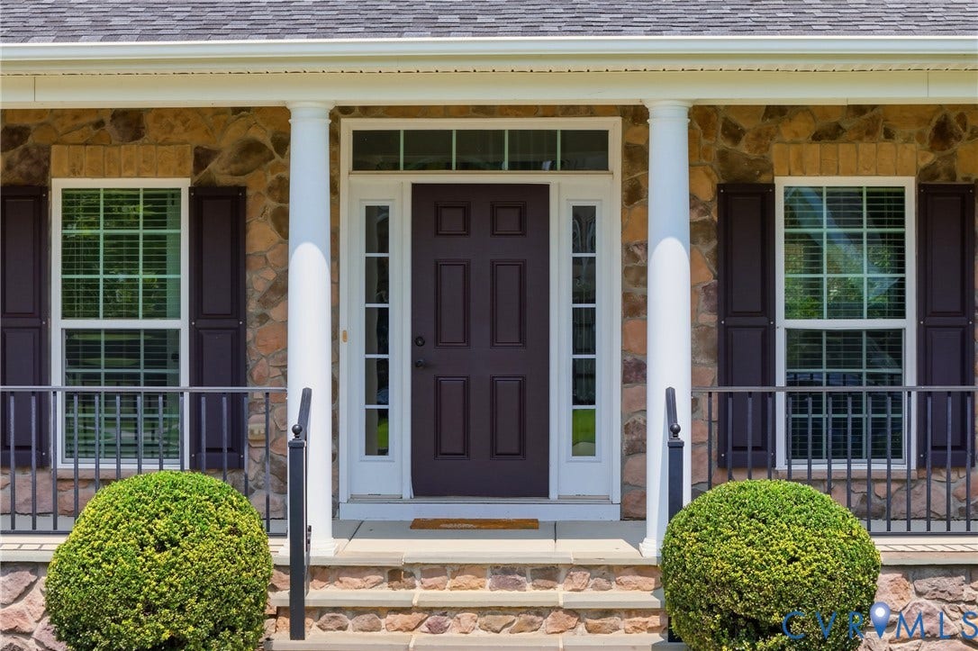 1819 White Mountain Drive, Mount Blanco On The James, Chester, VA 23836 Stone-clad facade featuring a dark paneled entry door with sidelights and transom window