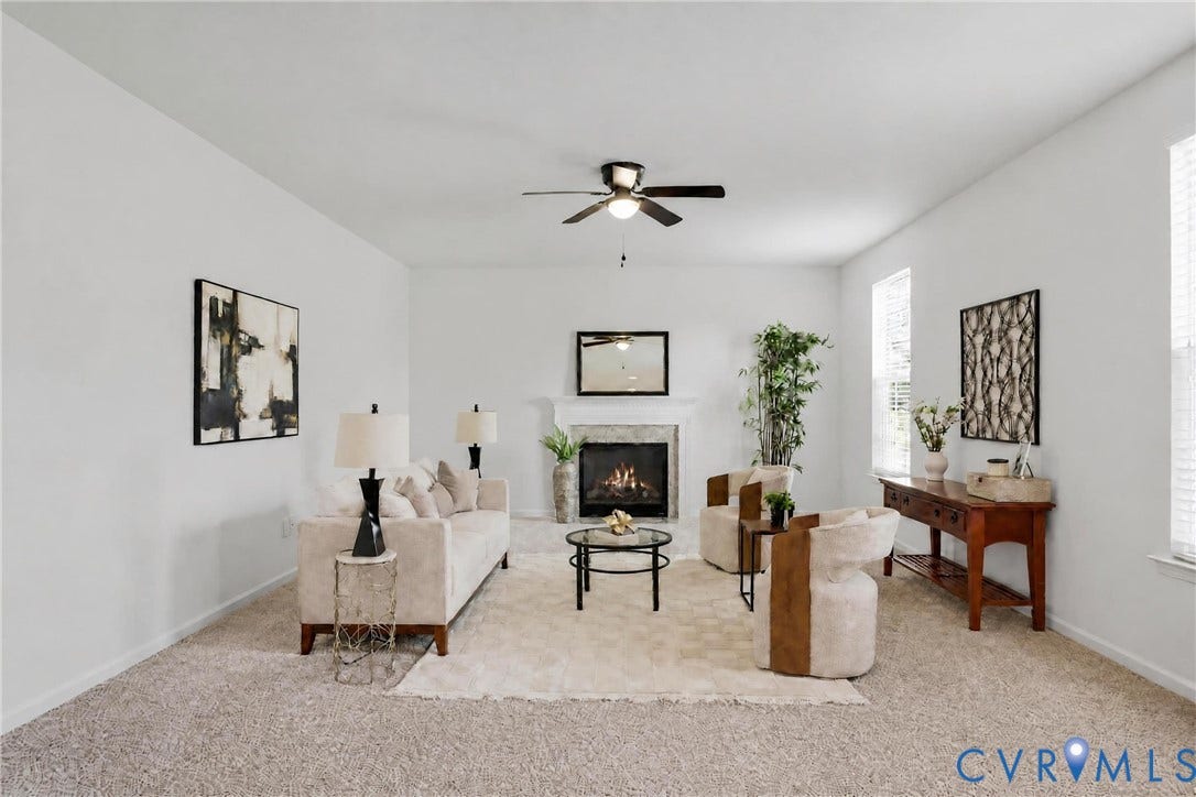 1819 White Mountain Drive, Mount Blanco On The James, Chester, VA 23836 Spacious living area featuring a stone-surround fireplace with a white mantel, ceiling fan, and multiple windows providing natural illumination