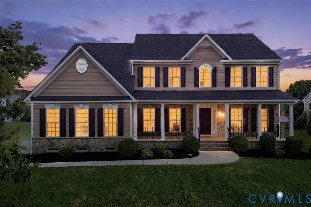 1819 White Mountain Drive, Mount Blanco On The James, Chester, VA 23836 Two-story residence featuring a stone and siding exterior, a covered front porch with white columns, dark shutters, and a prominent arched window on the second level
