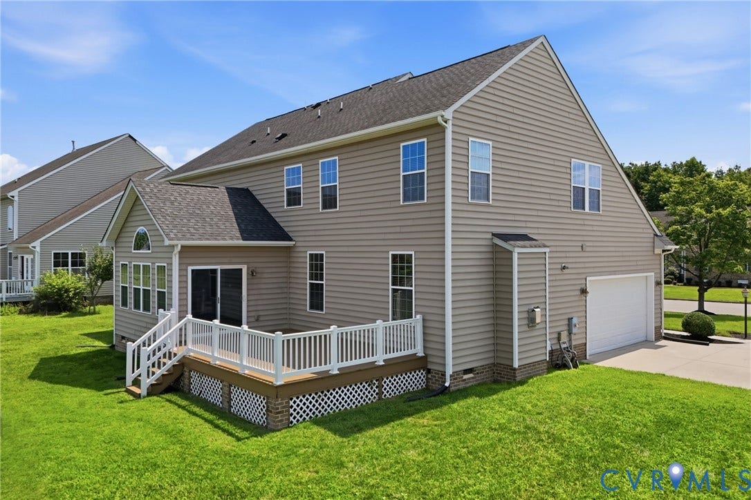 1819 White Mountain Drive, Mount Blanco On The James, Chester, VA 23836 Rear exterior featuring a multi-level deck with white railings, direct access from a sunroom, and an attached two-car garage