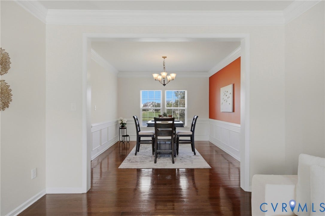 1819 White Mountain Drive, Mount Blanco On The James, Chester, VA 23836 Defined entryway leading to a formal dining area featuring wood-finish flooring, wainscoting, an accent wall, and a multi-arm chandelier