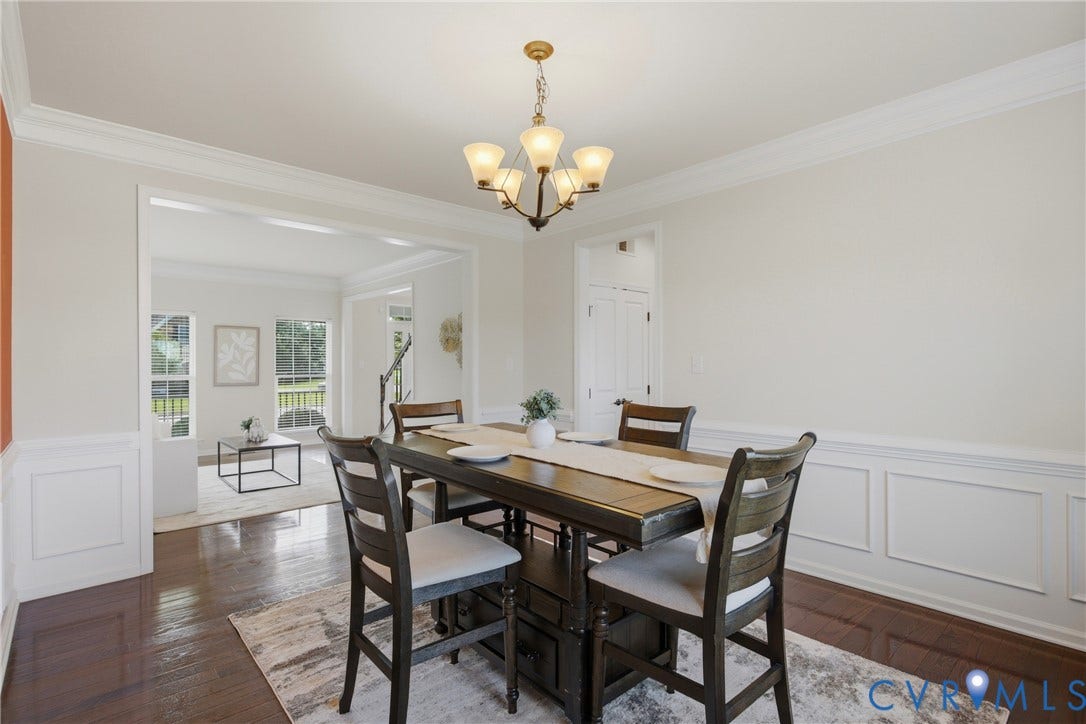 1819 White Mountain Drive, Mount Blanco On The James, Chester, VA 23836 Formal dining area featuring hardwood flooring, wainscoting, crown molding, and an elegant chandelier