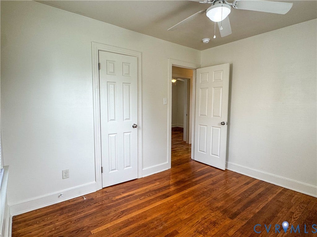 Room featuring wood flooring and a ceiling fan with integrated lighting