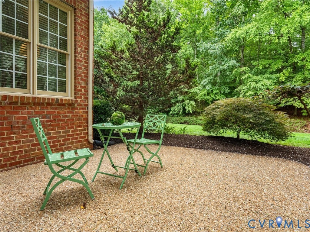 2214 Founders View Lane, Fb Golf Villas, Powhatan, VA 23113 Pebble patio featuring a red brick exterior and a privacy-enhancing natural tree line