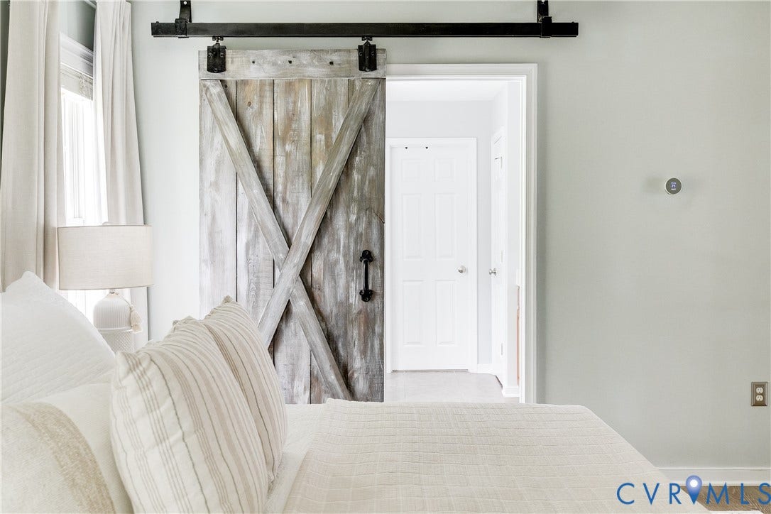 4907 Winding Branch Road, Moseley, VA 23120 Sliding barn door with distressed wood finish and X-brace design, featuring a black metal track and matching handle