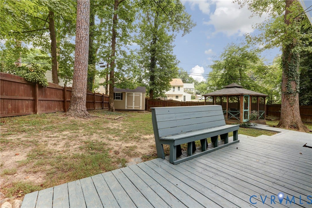 1401 Chowan Road, Henrico, VA 23229 Expansive backyard featuring a wood deck, a built-in gazebo, mature trees, a wooden privacy fence, and a detached storage shed