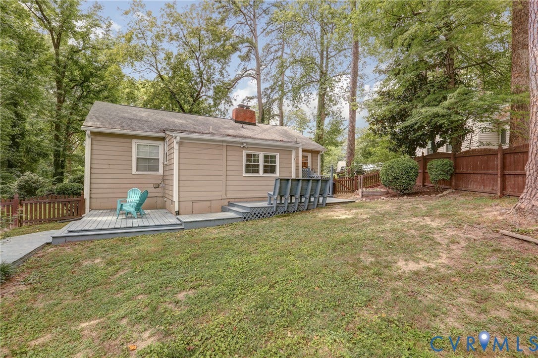1401 Chowan Road, Henrico, VA 23229 Rear exterior featuring a neutral-toned siding, a multi-level deck, a spacious grassy area, and mature trees