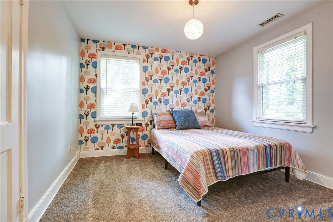 1401 Chowan Road, Henrico, VA 23229 Bedroom featuring a distinctive accent wall with a playful tree pattern, light gray painted walls, and neutral-toned carpeting