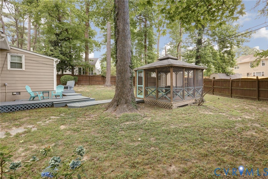 1401 Chowan Road, Henrico, VA 23229 Expansive backyard featuring a screened gazebo with X-pattern railings, a multi-level wooden deck, mature trees providing shade, and a privacy fence enclosing the perimeter