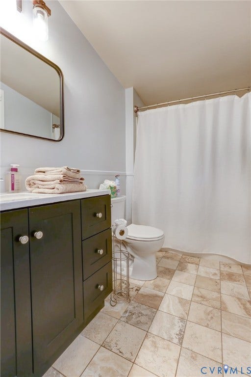 1401 Chowan Road, Henrico, VA 23229 Bathroom featuring a dark wood vanity with a white countertop, a rectangular mirror, a toilet, and patterned tile flooring