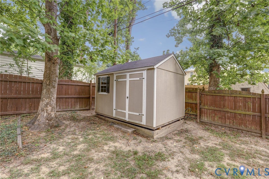 1401 Chowan Road, Henrico, VA 23229 Freestanding storage shed featuring a single window with shutters, double entry doors, and a dark shingled roof
