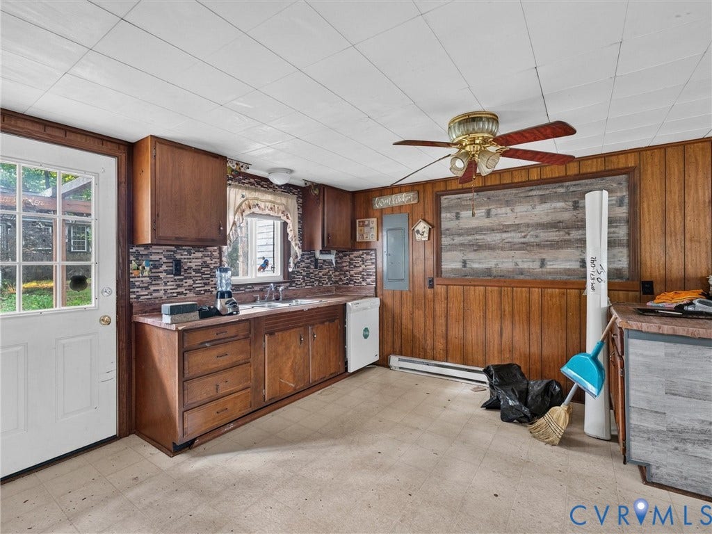 Kitchen area featuring wood cabinetry, a mosaic tile backsplash, and a double basin sink