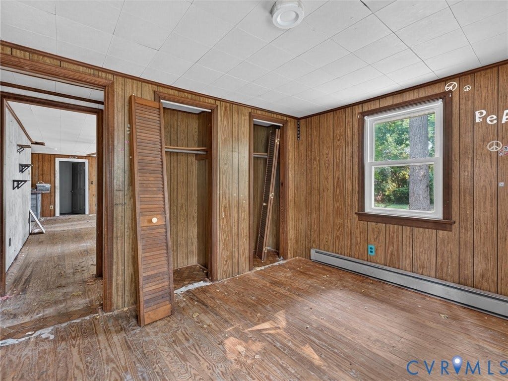 Room featuring wood-finish paneling, wood-finish flooring, and a white ceiling