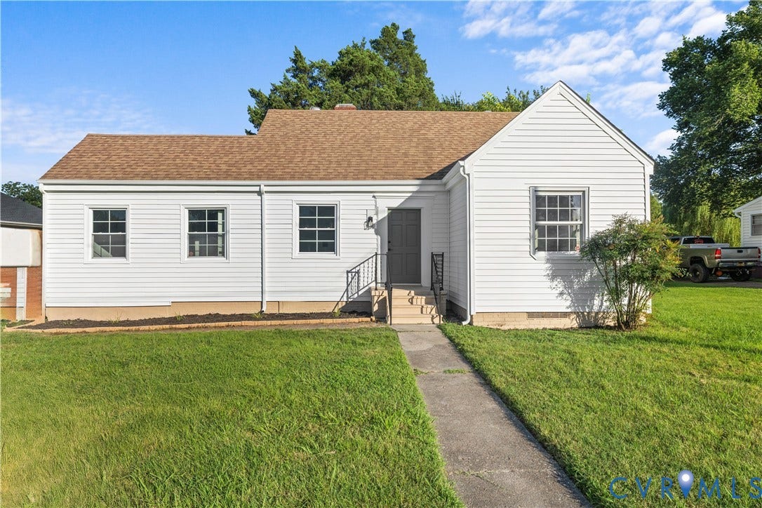 3516 Virginia Street, Woodlawn, Hopewell, VA 23860 White siding exterior featuring a brown shingle roof, multiple grid-pattern windows, a concrete walkway, and a landscaped front yard
