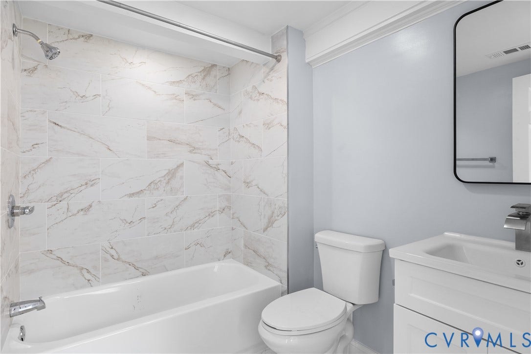 3516 Virginia Street, Woodlawn, Hopewell, VA 23860 Bathtub with white subway tile surround, chrome shower fixtures, white vanity with integrated sink, and contemporary rectangular mirror