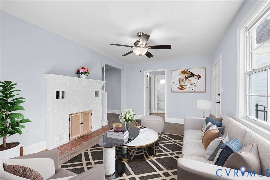 3516 Virginia Street, Woodlawn, Hopewell, VA 23860 (Virtually-Staged)White painted brick fireplace, wood-finish flooring, ceiling fan with integrated lighting, white trim and window frames, and light-colored wall paint