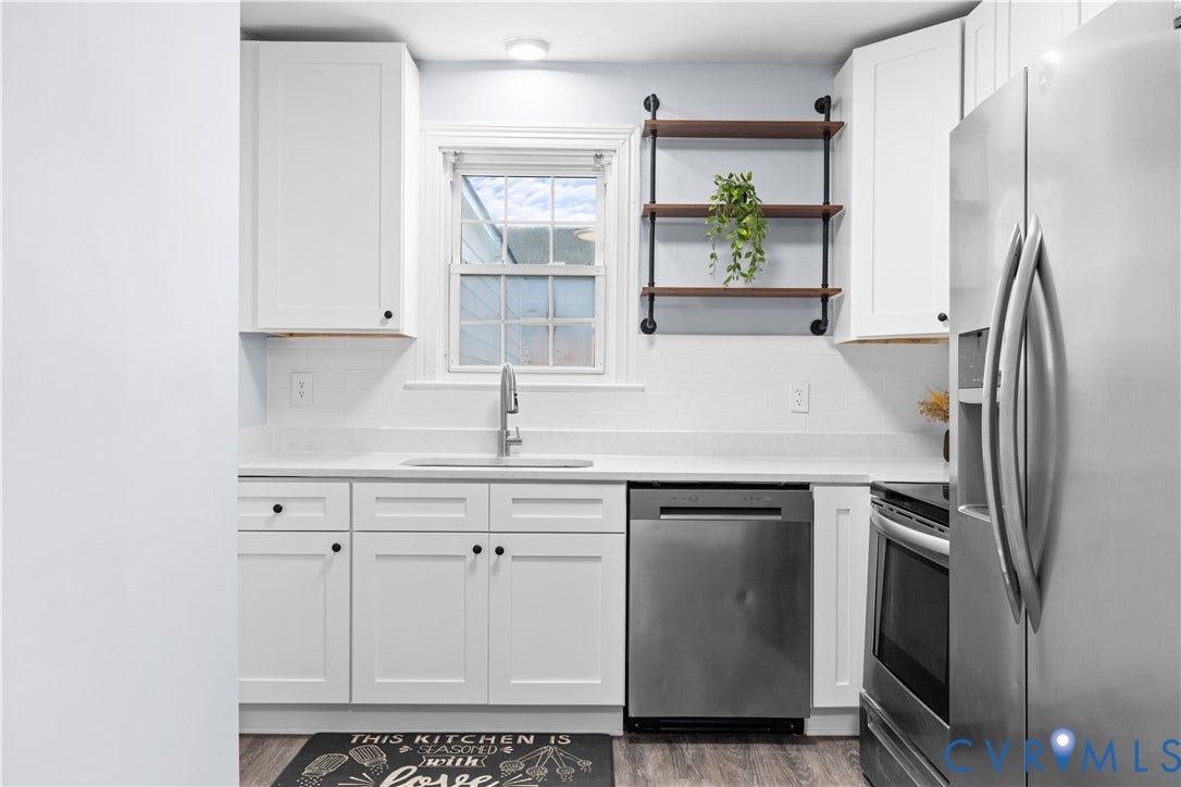 3516 Virginia Street, Woodlawn, Hopewell, VA 23860 White shaker cabinetry, quartz countertops, stainless steel appliances, subway tile backsplash, and wood-finish flooring