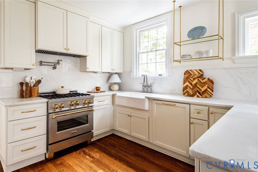 3912 Park Avenue, Malvern Gardens, Richmond, VA 23221 Well-appointed kitchen featuring a professional-grade SS range w/gold accents, white cabinetry with brass hardware, Quartz countertops and backsplash, a farmhouse sink, and refinished hardwood flooring
