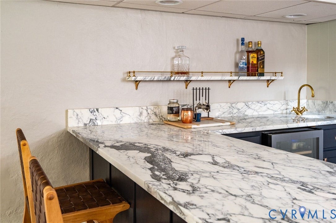 3912 Park Avenue, Malvern Gardens, Richmond, VA 23221 Wet bar featuring extensive white and gray countertops, a brass faucet and hammered sink, a built-in beverage refrigerator
