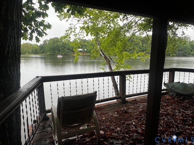 35 Lake Drive, Columbia, VA 23038 Expansive deck featuring a lake backdrop, dark wood decking, and decorative metal balusters