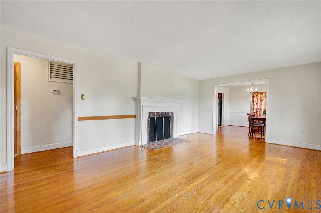 1910 Fon Du Lac Road, Henrico, VA 23229 Spacious living area featuring wood-finish flooring, a traditional fireplace with a brick hearth, and a decorative mantel