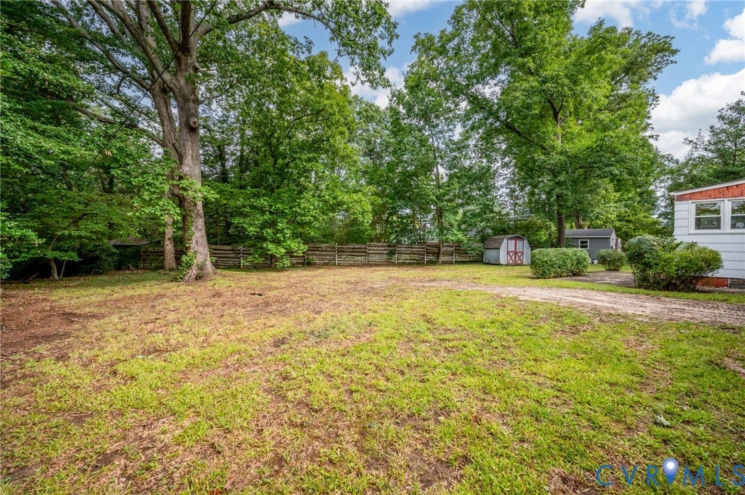 1910 Fon Du Lac Road, Henrico, VA 23229 Spacious yard with a partial wood fence, mature trees, and two storage sheds