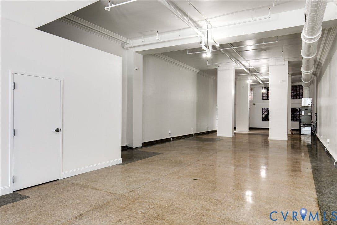 304 E Grace Street, Richmond, VA 23219 Spacious open-concept interior featuring polished concrete flooring, exposed ceiling ductwork, and white painted walls