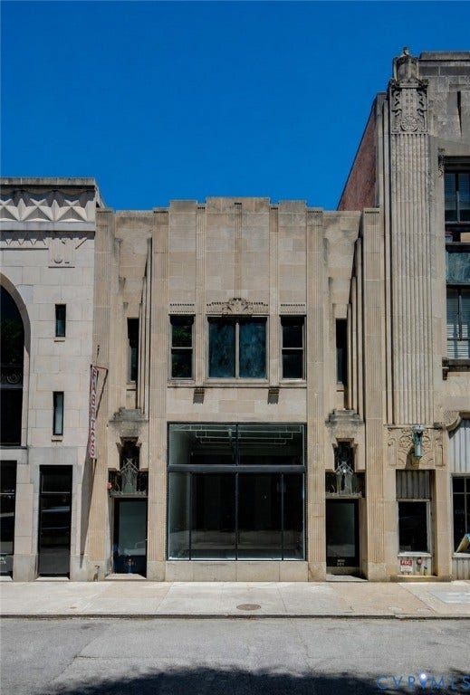 304 E Grace Street, Richmond, VA 23219 Stone-clad commercial facade featuring a large display window, two entryways, and upper-level windows