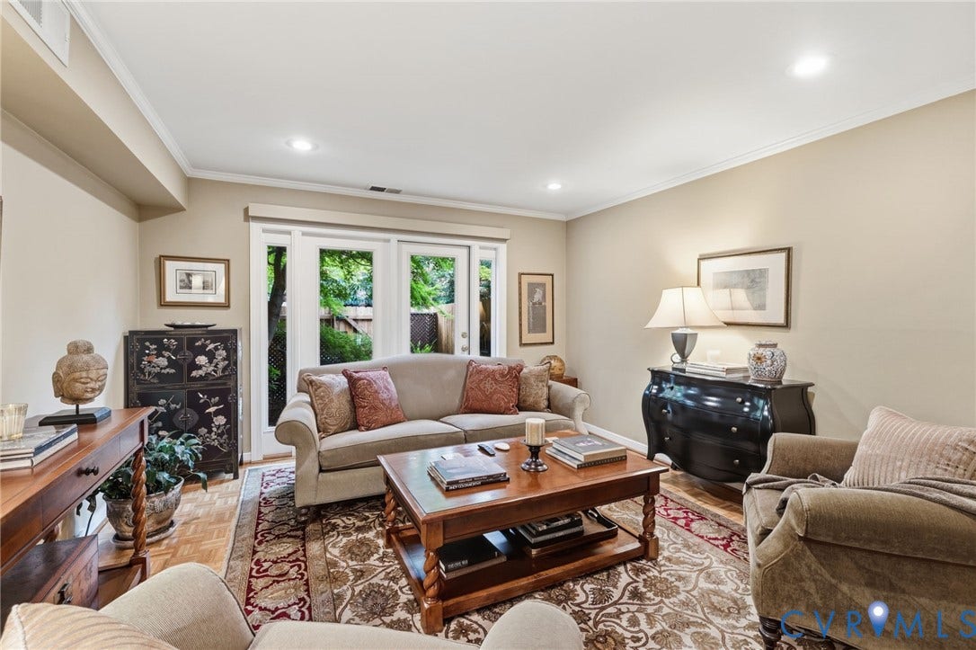 Living area with light-toned wall finishes, recessed lighting, crown molding, and wood-finish flooring