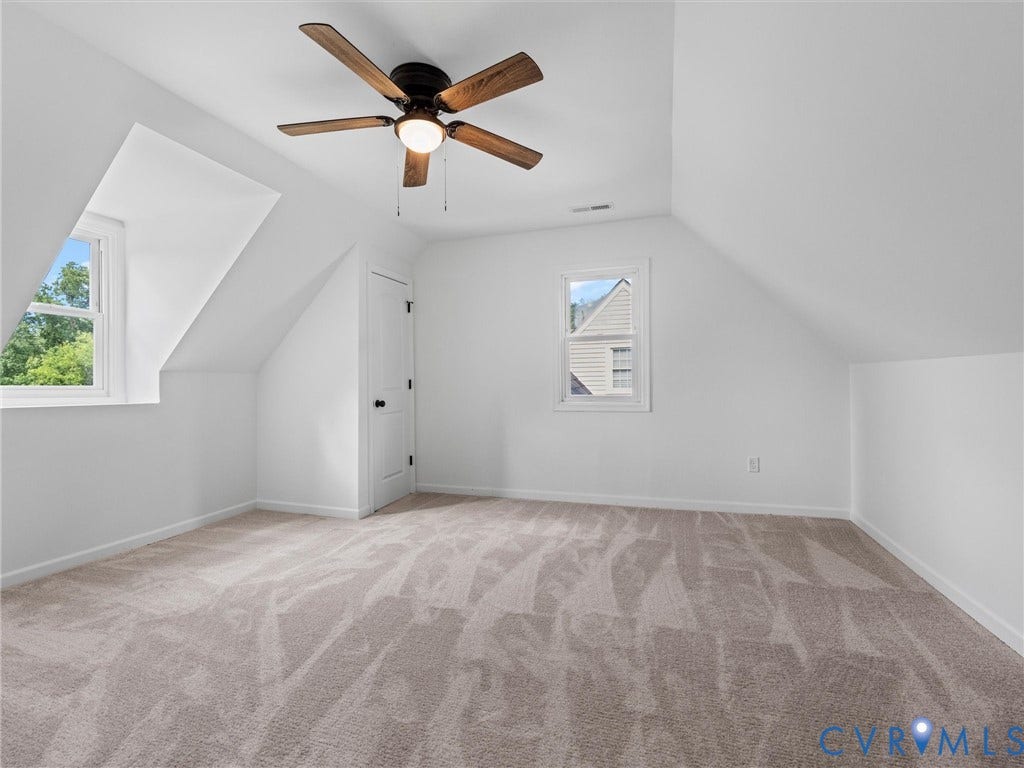 507 Grayson Avenue, Richmond, VA 23222 Spacious room featuring vaulted ceilings, a ceiling fan with integrated lighting, two windows with natural light, and neutral-toned carpeting