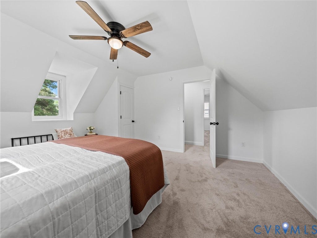 507 Grayson Avenue, Richmond, VA 23222 Carpeted room featuring a ceiling fan with wood-finish blades, a single window, and a white paneled door with black hardware