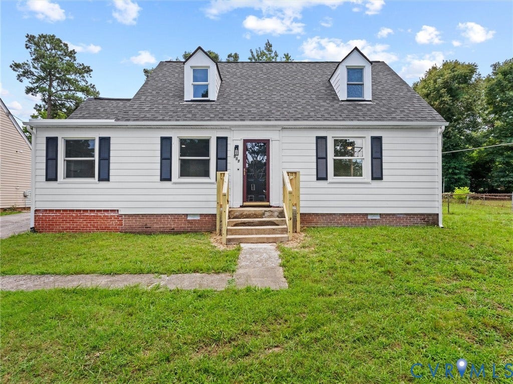 507 Grayson Avenue, Richmond, VA 23222 White siding exterior with a dark shingle roof, twin dormer windows, blue window shutters, and a red brick foundation