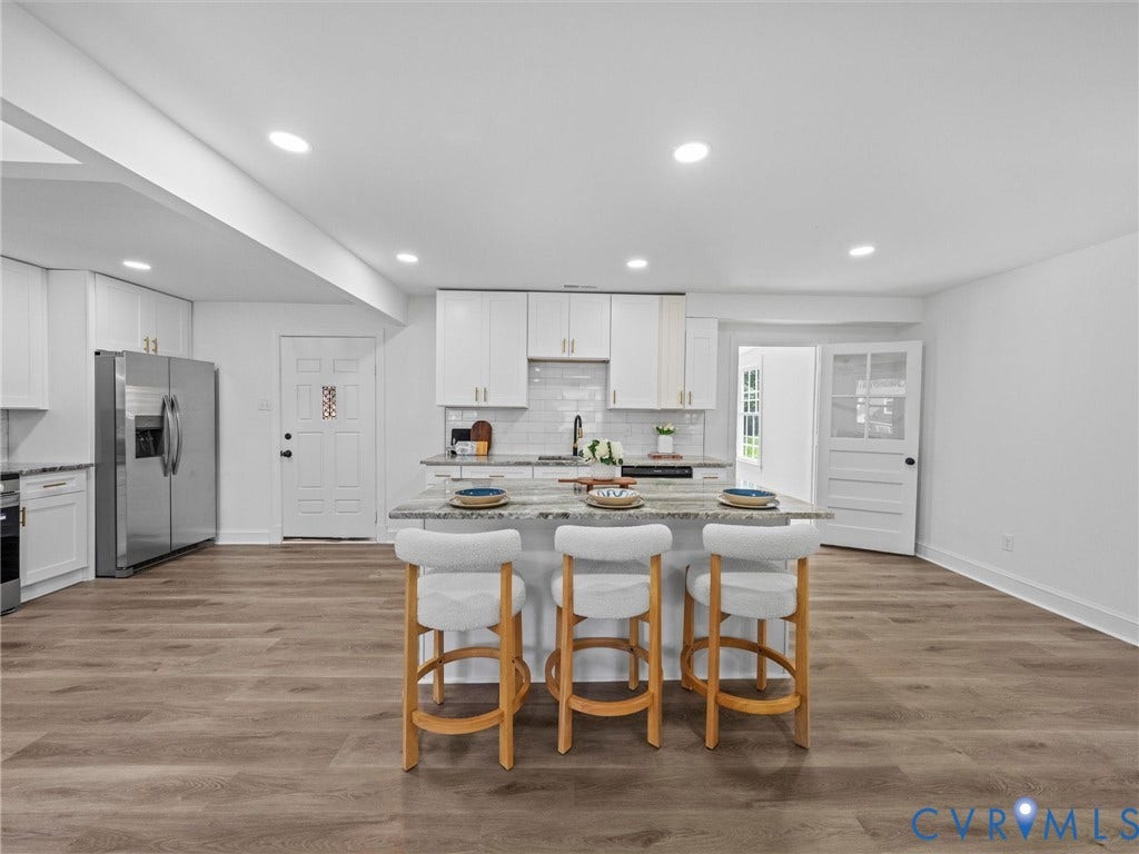 507 Grayson Avenue, Richmond, VA 23222 Open-concept kitchen with a central island featuring a light-toned countertop, white cabinetry with gold-tone hardware, a white subway tile backsplash, and recessed lighting throughout