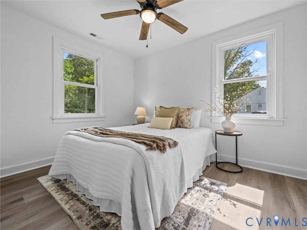 507 Grayson Avenue, Richmond, VA 23222 Bright room featuring wood-finish flooring, two large windows with white trim, and a ceiling fan with light fixture