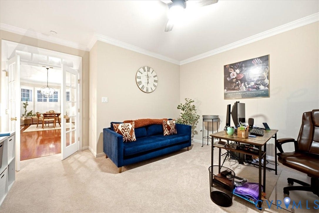 Carpeted room featuring crown molding and a ceiling fan