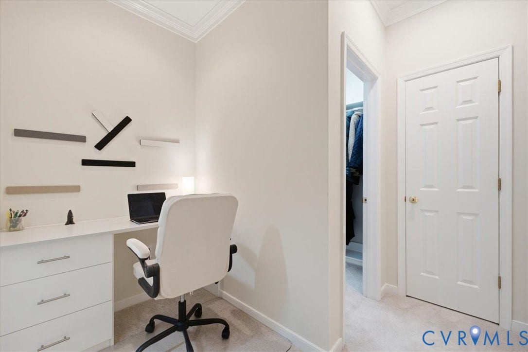 Recessed lighting illuminates the neutral wall colors and crown molding